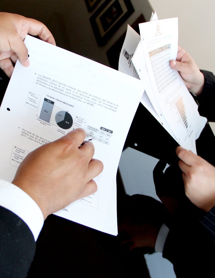 creative A business team reviewing charts and graphs on documents, emphasizing data analysis and teamwork.